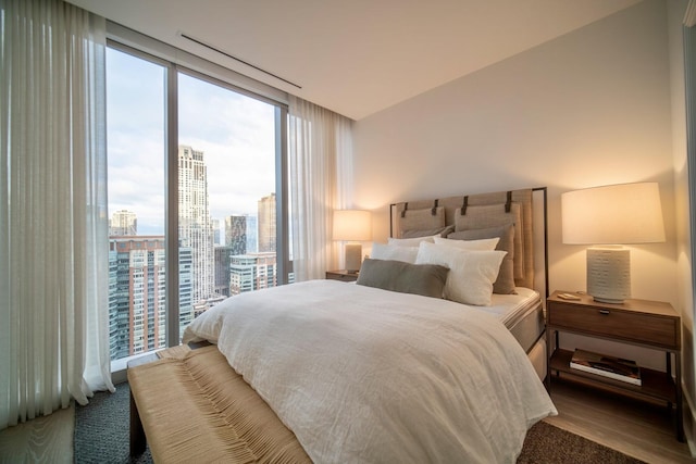 bedroom with floor to ceiling windows, wood-type flooring, and multiple windows