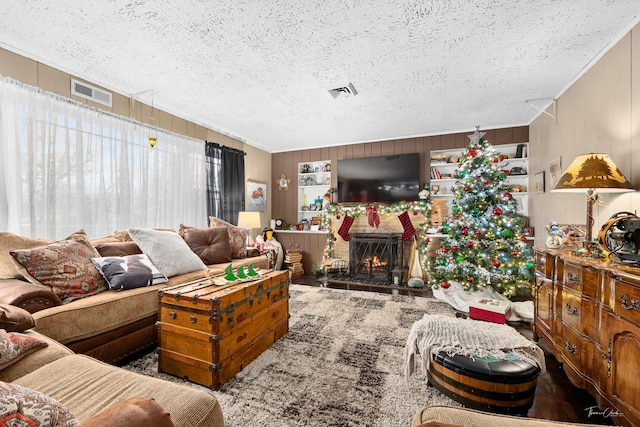 living room featuring wood walls and a textured ceiling