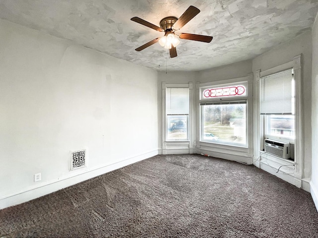 carpeted empty room featuring ceiling fan, cooling unit, and a textured ceiling