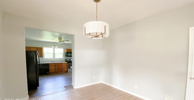 unfurnished dining area with ceiling fan, sink, and light hardwood / wood-style floors