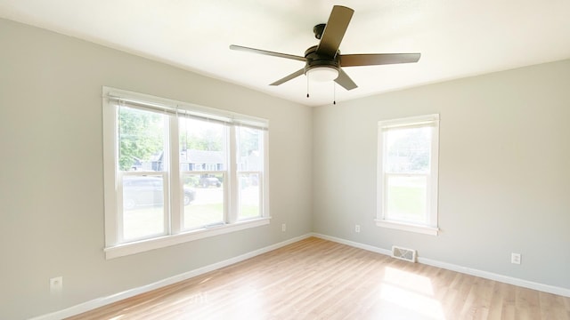 empty room with ceiling fan, a healthy amount of sunlight, and light wood-type flooring