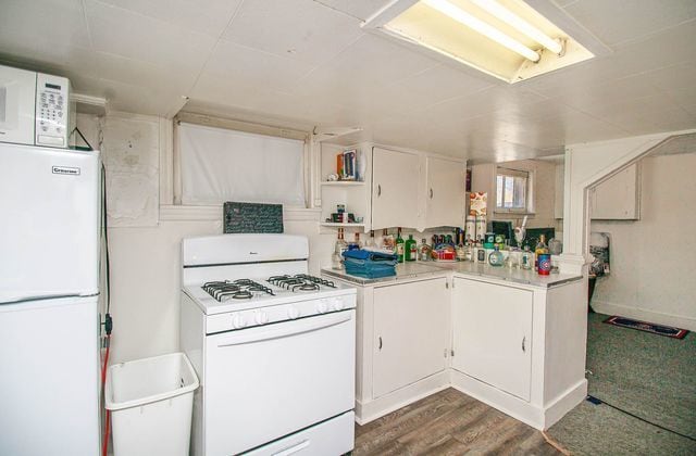 kitchen featuring white cabinets, white appliances, and dark wood-type flooring