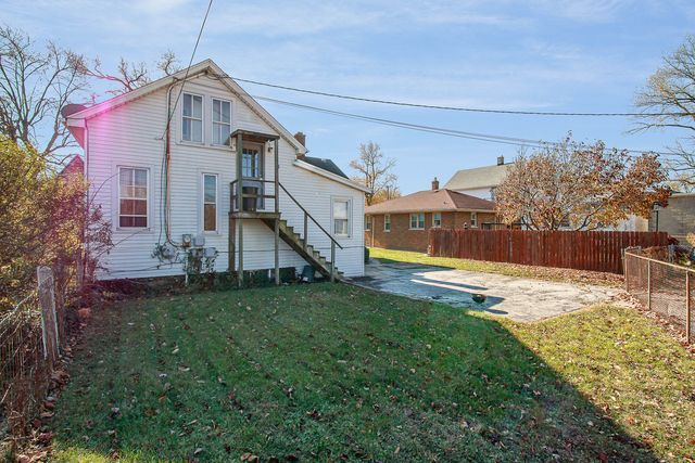 back of property featuring a lawn and a patio