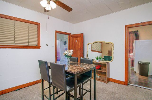 dining space featuring light carpet and ceiling fan