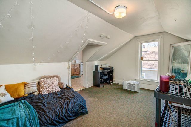 bedroom featuring dark colored carpet and vaulted ceiling