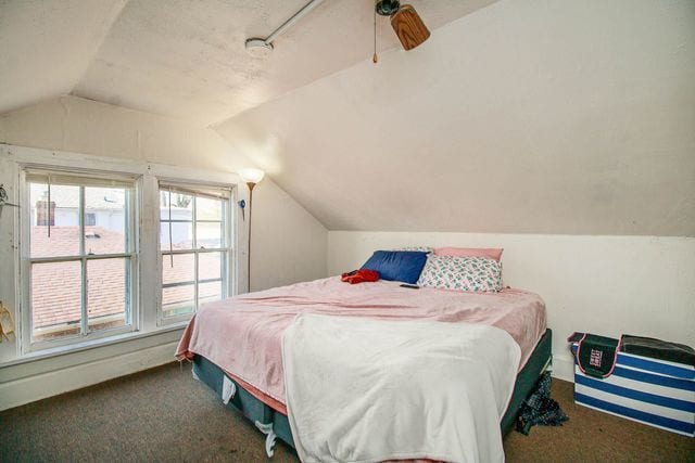 carpeted bedroom with ceiling fan and lofted ceiling