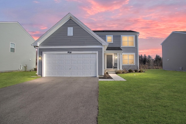 view of property featuring a lawn and a garage