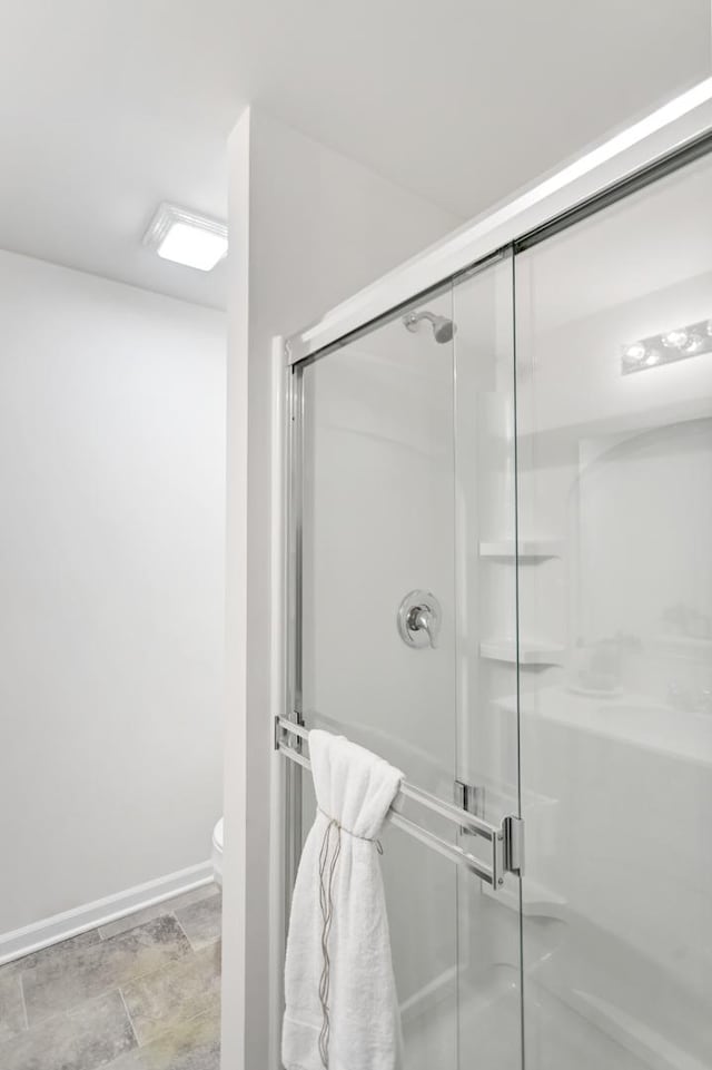 bathroom with an enclosed shower and toilet