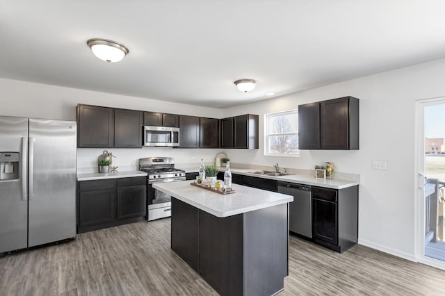 kitchen featuring a kitchen island, stainless steel appliances, dark brown cabinets, and sink