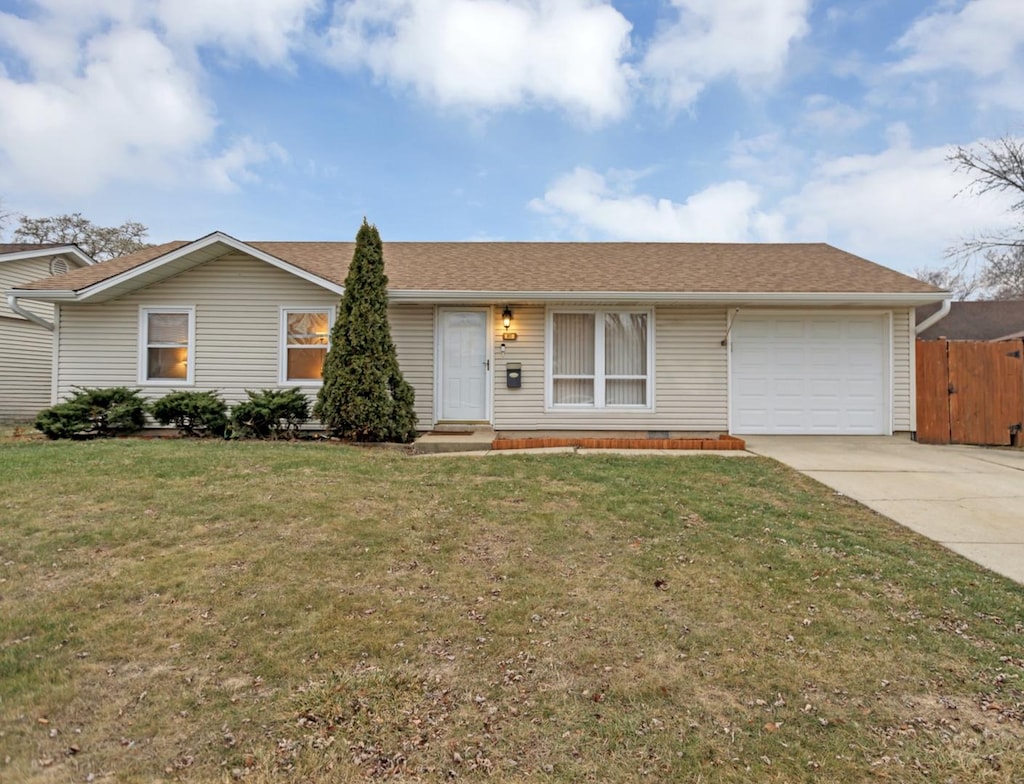 ranch-style home with a garage and a front lawn