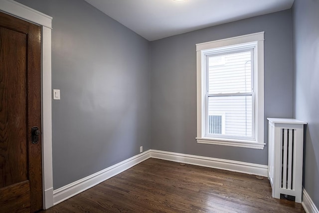 unfurnished room featuring plenty of natural light and dark wood-type flooring