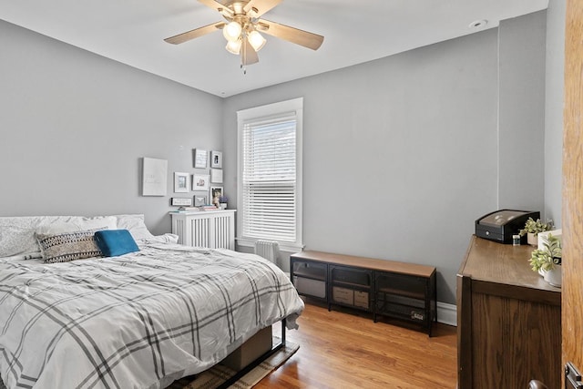 bedroom featuring radiator, ceiling fan, and light wood-type flooring