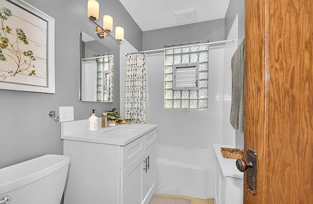 full bathroom featuring vanity, toilet, shower / bath combo with shower curtain, and a wealth of natural light