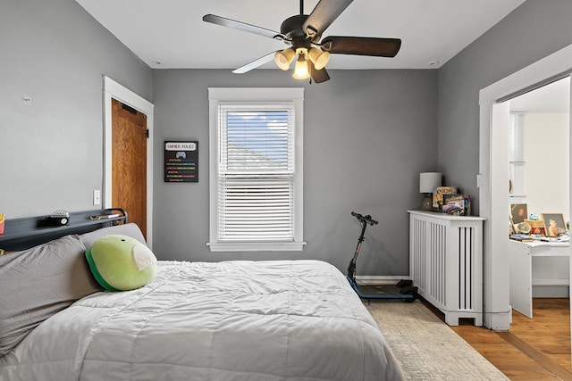 bedroom featuring ceiling fan, light hardwood / wood-style flooring, and radiator heating unit