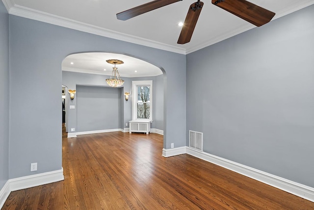 empty room featuring hardwood / wood-style floors, ceiling fan, crown molding, and radiator