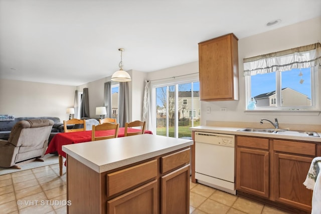 kitchen featuring white dishwasher, sink, pendant lighting, a center island, and light tile patterned flooring