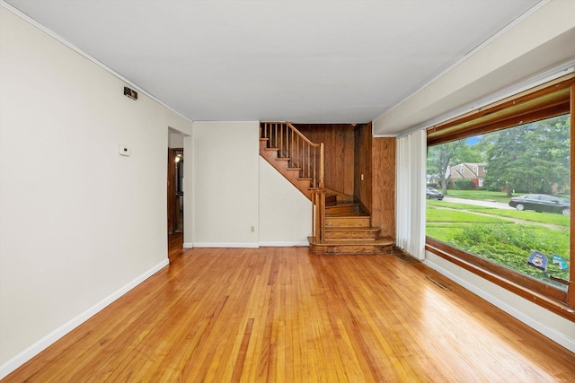 unfurnished living room with light hardwood / wood-style floors and crown molding