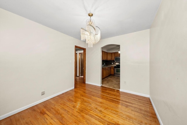 unfurnished dining area with light hardwood / wood-style flooring and an inviting chandelier