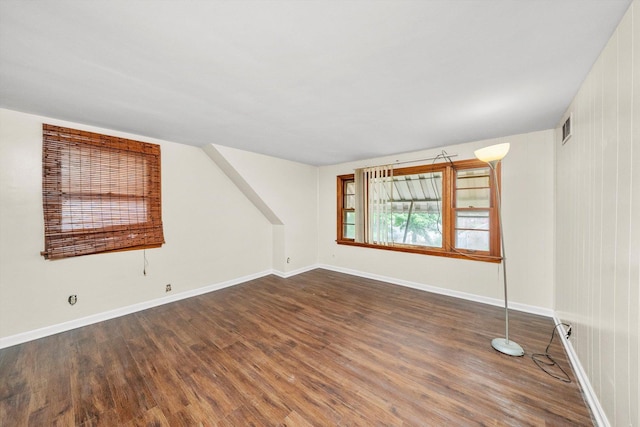 spare room featuring dark hardwood / wood-style floors and wooden walls