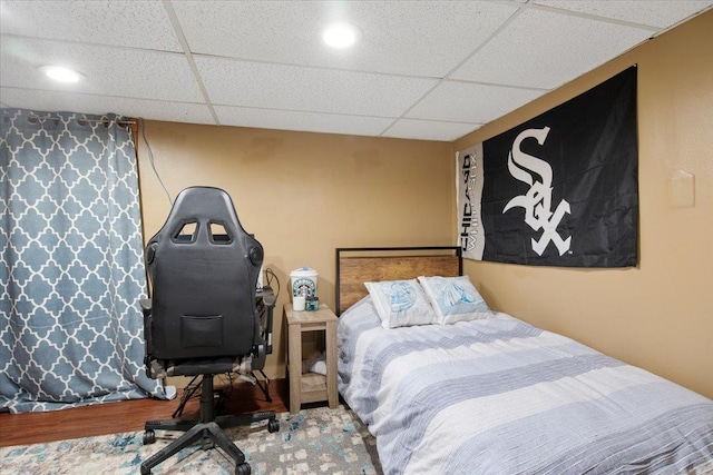 bedroom featuring hardwood / wood-style floors and a drop ceiling