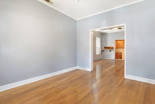 spare room featuring light hardwood / wood-style floors and crown molding