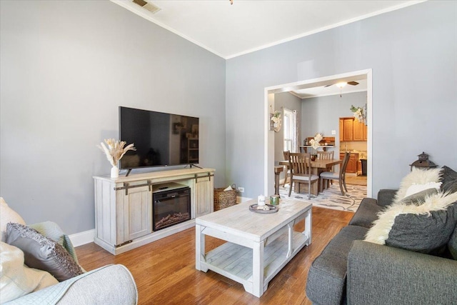 living room featuring light wood-type flooring and ornamental molding