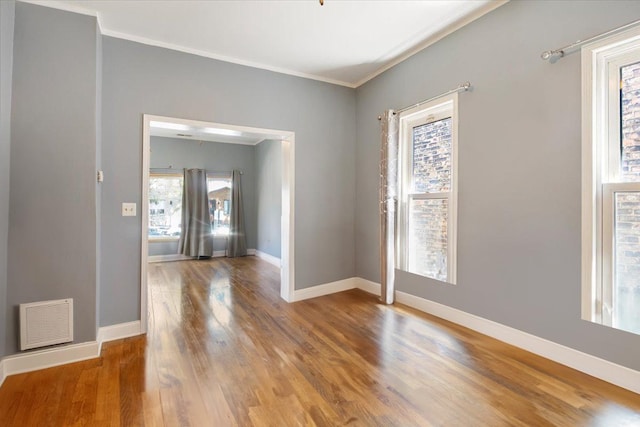 empty room featuring crown molding and hardwood / wood-style floors