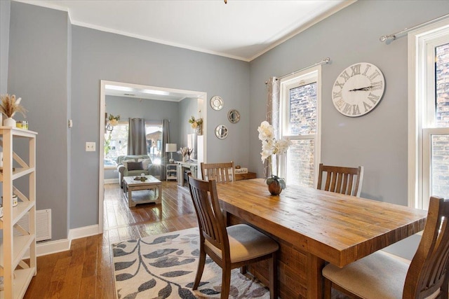 dining space featuring crown molding and dark hardwood / wood-style floors