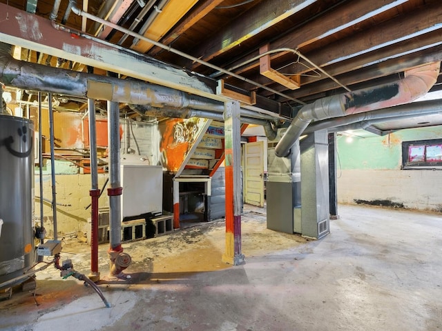 basement featuring heating unit, gas water heater, and washer / dryer