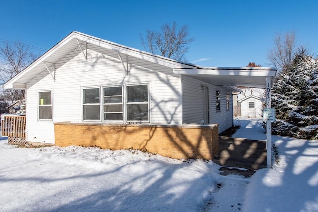 view of snow covered exterior with a carport