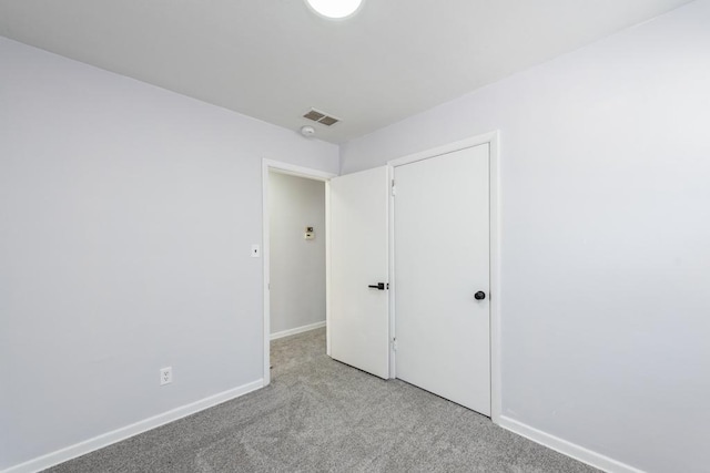 unfurnished bedroom with light carpet and a closet