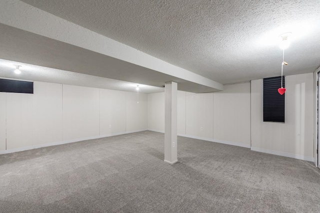 basement featuring a textured ceiling and carpet