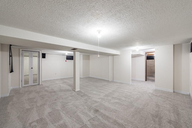 basement featuring light carpet and a textured ceiling