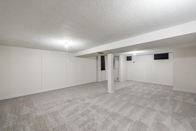 basement with light colored carpet and a textured ceiling