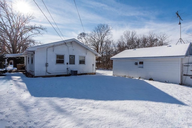 snow covered rear of property with cooling unit