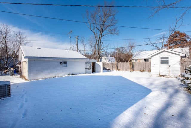 snowy yard with a shed and cooling unit