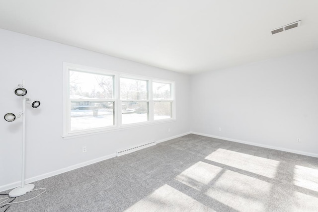 empty room featuring a baseboard radiator and carpet floors