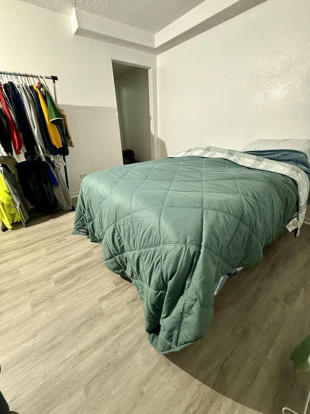 bedroom featuring a textured ceiling and light wood-type flooring