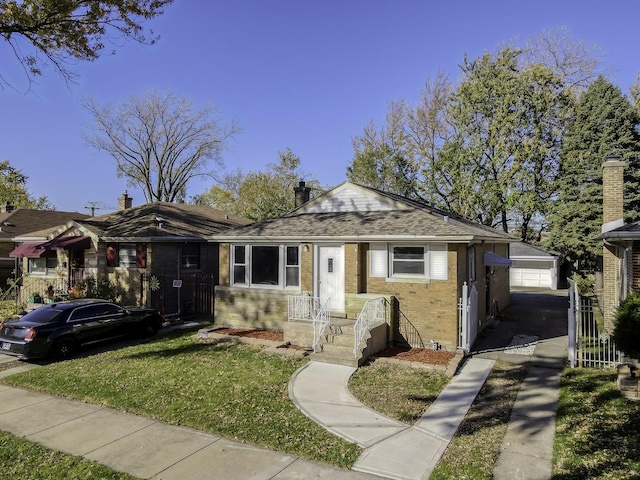 view of front of house featuring a garage, a front lawn, and an outdoor structure