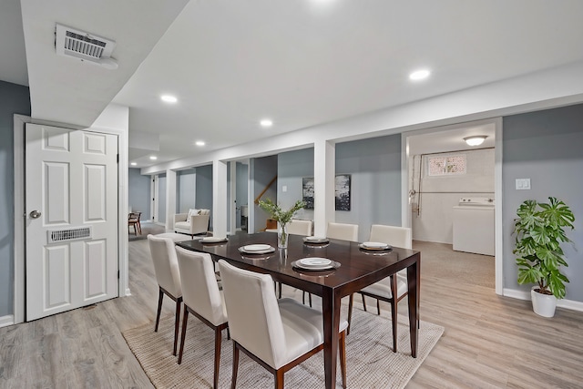 dining space with washer / clothes dryer and light hardwood / wood-style floors