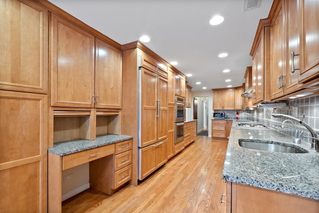 kitchen with visible vents, decorative backsplash, appliances with stainless steel finishes, built in study area, and a sink