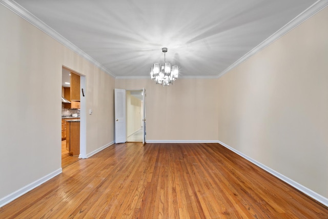 unfurnished room with light wood finished floors, baseboards, ornamental molding, and a notable chandelier