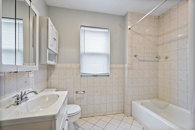 bathroom featuring toilet, vanity, a wealth of natural light, and tile patterned floors