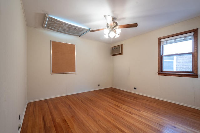 unfurnished room with light wood finished floors, baseboards, a ceiling fan, and a wall mounted air conditioner