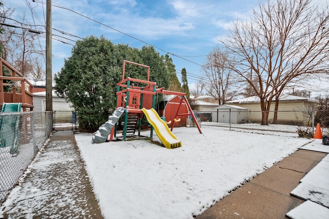 snow covered playground with a playground and fence