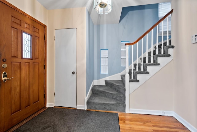 entryway featuring stairway, wood finished floors, and baseboards