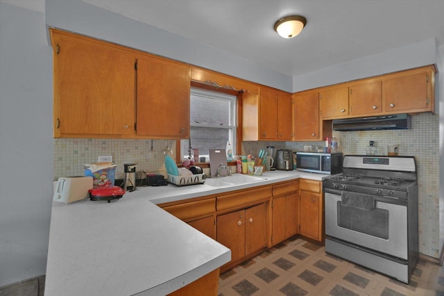 kitchen with decorative backsplash, sink, and stainless steel appliances