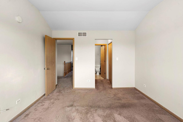 unfurnished bedroom with carpet floors and lofted ceiling