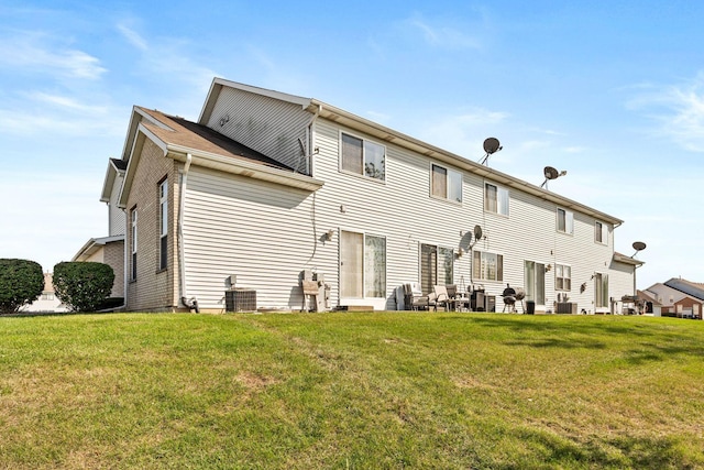 back of house with central AC and a yard