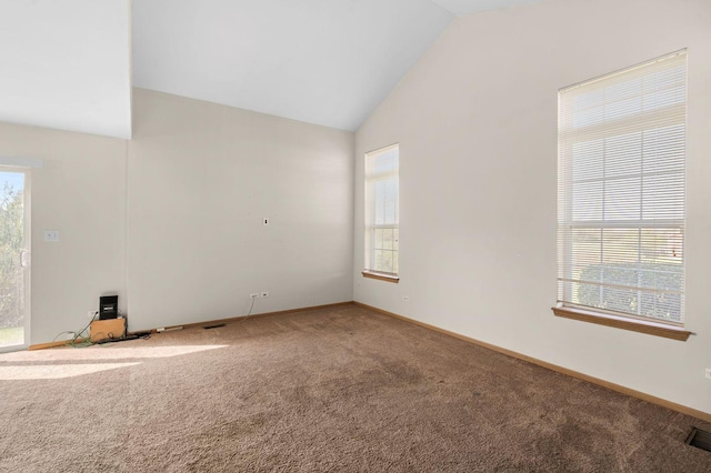 unfurnished room featuring carpet, lofted ceiling, and a healthy amount of sunlight